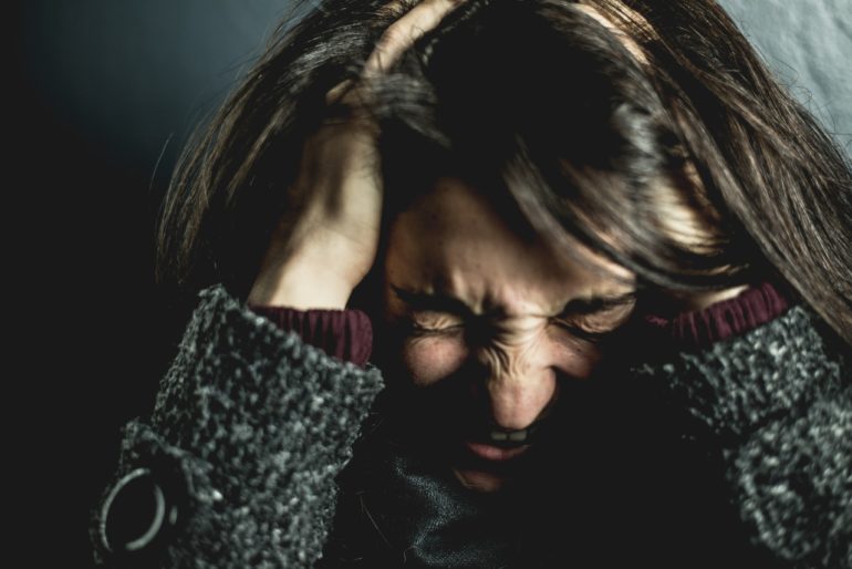 woman-holding-her-head-2128817-770x514