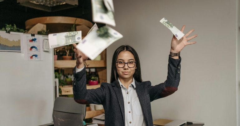 žena hádže výplatu do vzduchu, je zúfalá