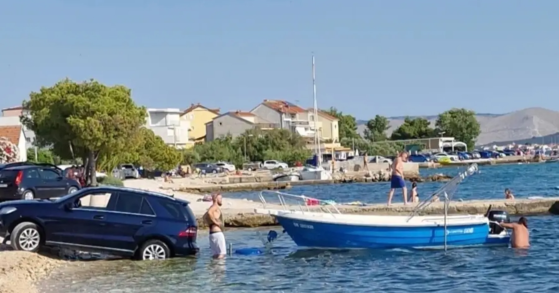 Muži parkujú čln do mora