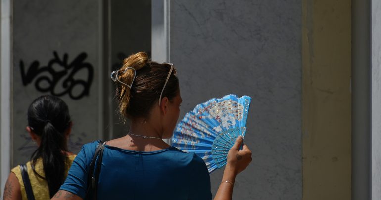 Žena sa ovieva vejárom počas horúčavy