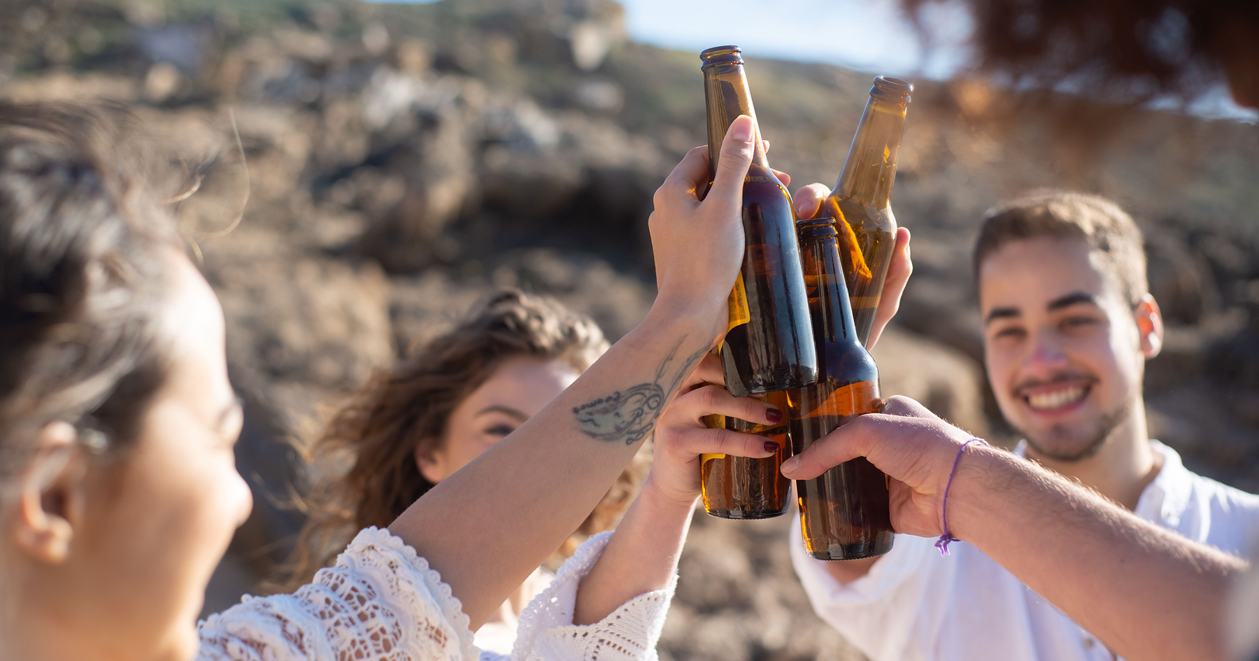 Kamaráti štrngajú s fľaškami alkoholu