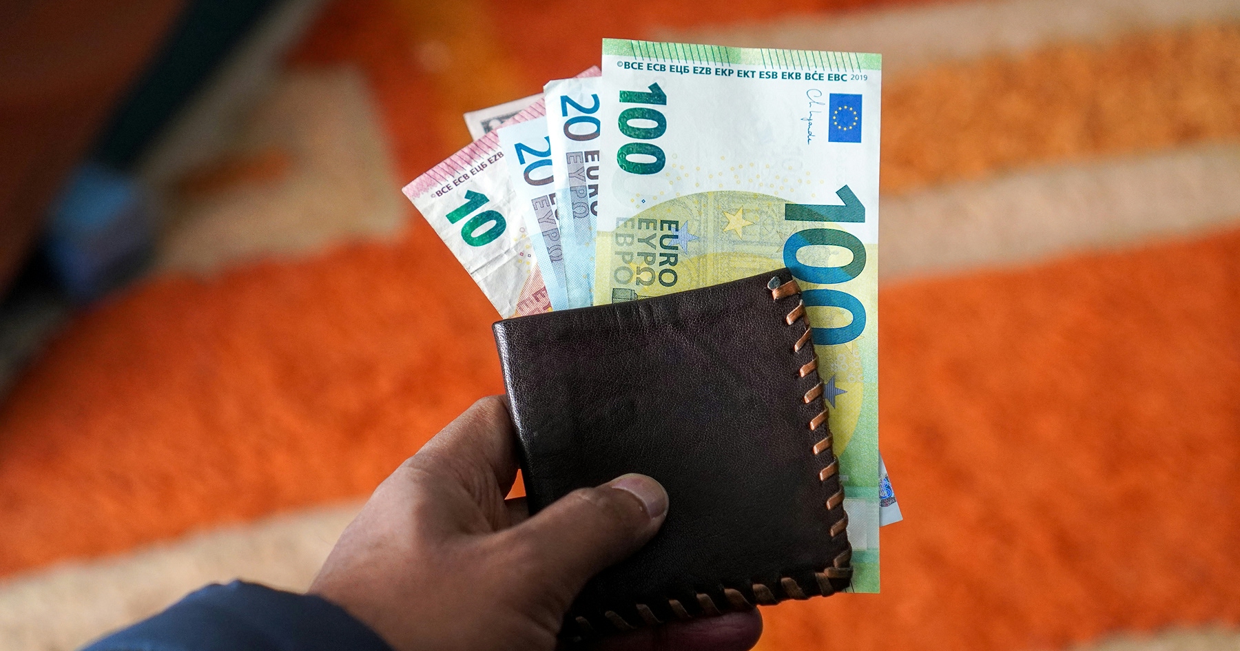 Muž drží peňaženku s peniazmi