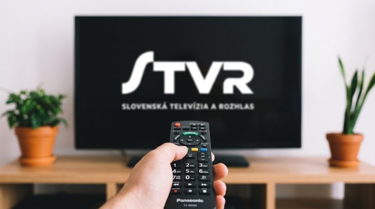 Záber na ovládač a na TV logo STVR