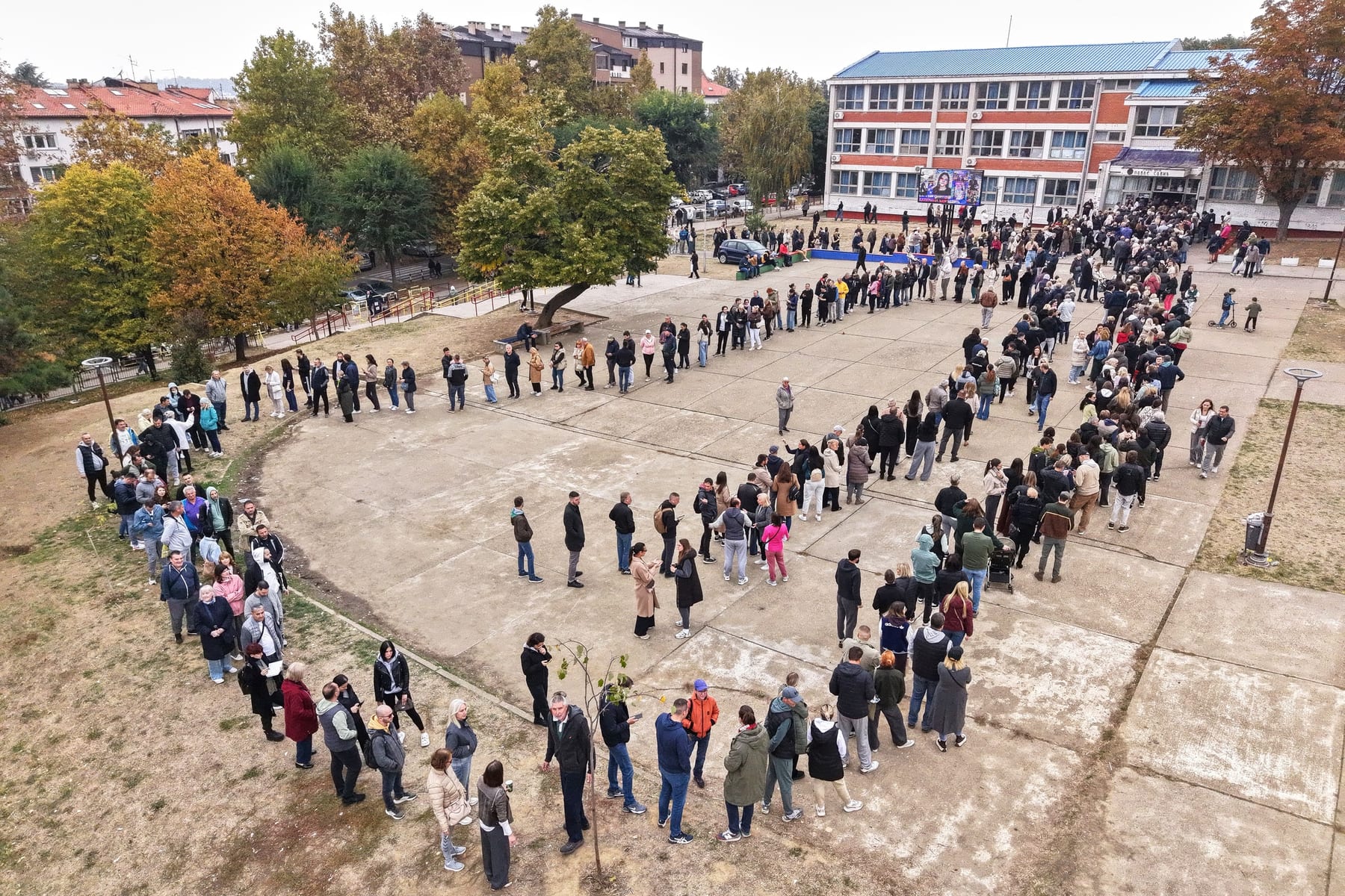 Ľudia stoja v radoch pred volebnou miestnosťou počas parlamentných volieb v Belehrade v Srbsku.