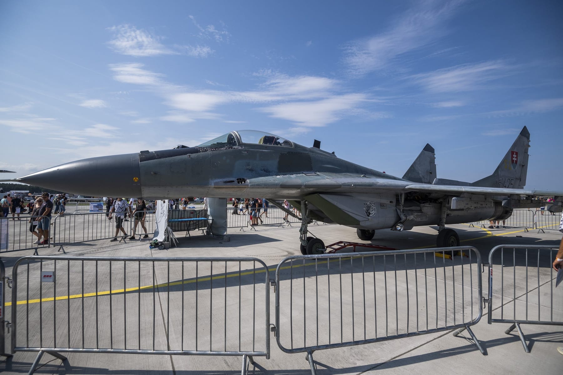 Návštevníci kráčajú okolo slovenskej stíhačky MIG-29 na 11. ročníku Medzinárodných leteckých dní SIAF v priestoroch Leteckej základne Malacky-Kuchyňa v sobotu