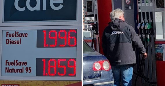 Záber na tabuľu s cenami pohonných hmôt a na muža na benzínke
