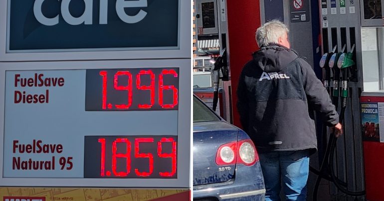 Záber na tabuľu s cenami pohonných hmôt a na muža na benzínke